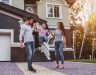Young couple swings their child in front beautifully remodeled home exterior