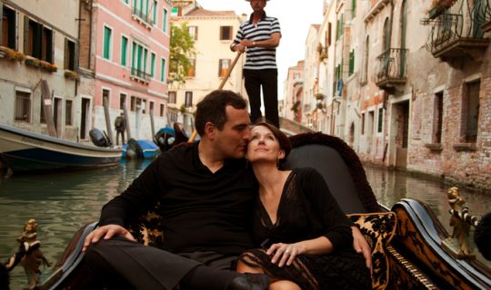 Man and woman enjoying a romantic gondola ride in Venice.