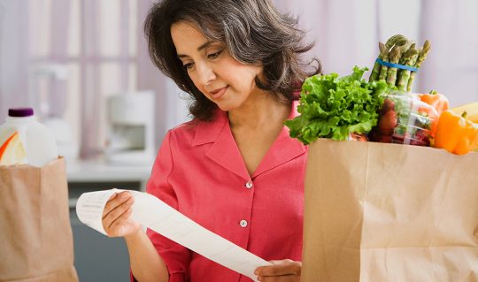 Woman looks at her grocery receipt
