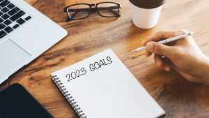 Writing 2023 financial goals in a notebook