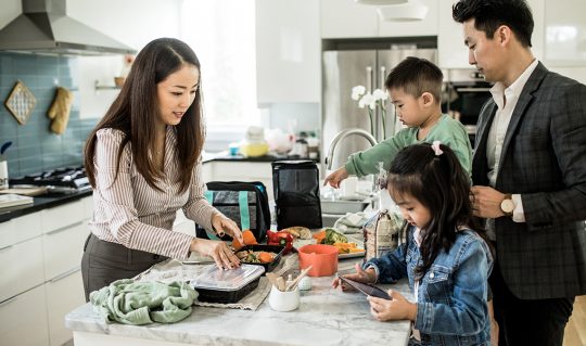 Parents prepare meals with their two young children